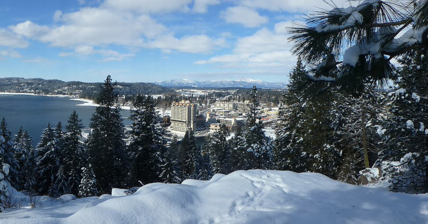 Distant view of an Idaho city amid snow covered mountains and trees