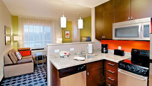 Modern, divided living room and kitchen with green and orange walls