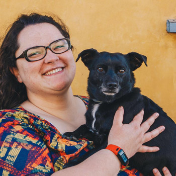 dark haired woman holding a black chihuahua